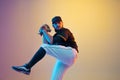 Baseball player, pitcher in a black uniform practicing on gradient background in neon light Royalty Free Stock Photo