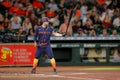 a baseball player standing at home plate holding a bat in his hand