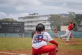 Baseball player stands at home plate, ready to swing the bat, while other players on diamond field Royalty Free Stock Photo