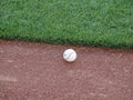 Baseball rest on edge of warning track beyond the outfield grass