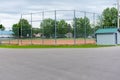 Baseball or softball diamond through a fence in park in a small town Canadian city of Brighton near Pesquile Lake Provincial Park