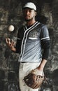 Baseball, sports and uniform with a man athlete on a dark background wearing a mitt while holding a ball. Portrait Royalty Free Stock Photo