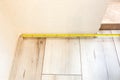 Baseboard installation. Repair works indoors. Renovation in the flat. Tape measure