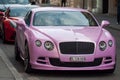 Closeup of pink Bentley front parked in the street