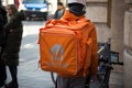 delivery man with just eat back pack standing in the street with bicycle