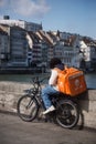 Portrait of deliver man with orange back pack just eat waiting on bicycle in the street Royalty Free Stock Photo