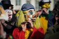 portrait of masked people wearing traditional costume playing flute parading in the street