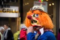 Masked people wearing traditional costume playing flute parading in the street