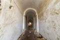 Basement of old fortress building, long narrow corridor with vaulted plastered ceiling and dirty floor Royalty Free Stock Photo