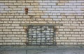 Basement Window With A Lattice In The Brick Wall Is Laid With Bricks
