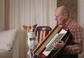 Basenji dog and mature musician with accordion prepare to perform learning new song