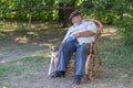 Basenji dog waiting till senior master rest in a wicker rocking chair and play with his dog Royalty Free Stock Photo