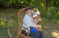 Basenji licks the masters face while sitting on the hands inside of whicker rocking chair Royalty Free Stock Photo