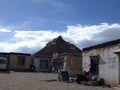 Basic accommodation & guest houses by Lake Manasarovar shore, with Chiu Gompa, a small temple on steep hill in background, Tibet