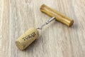 A basic corkscrew with a cork on a wooden table. Tokaji is wine`s name written on cork from Tokaj wine region Royalty Free Stock Photo