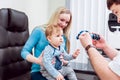 Basic eye examination. Mother holds child during eye exam.