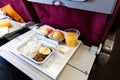 Basic inflight meal consisting rice, egg, beef curry, bread, juice