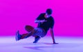 Portrait of dancing man, break dancer in action, motion in modern clothes isolated over bright magenta background at Royalty Free Stock Photo