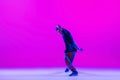 Portrait of dancing man, break dancer in action, motion in modern clothes isolated over bright magenta background at Royalty Free Stock Photo
