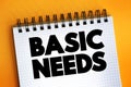 Basic Needs text on notepad, concept background Royalty Free Stock Photo