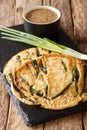 Basic recipe Pajeon Korean pancakes with green onions close-up on a slate board. vertical