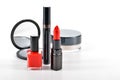 Basic red makeup cosmetics on white background.