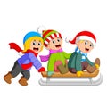 An excited boys are playing on the ice board cart and some of them pulls it Royalty Free Stock Photo