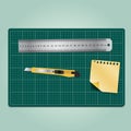 Working equipment ,cutter, ruler and paper on the green cutting mat Royalty Free Stock Photo