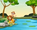 Happy zookeeper boy and lion near a river Royalty Free Stock Photo