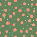 Orange and white lollipop with light snow on calm green background, Seamless Christmas candy winter pattern. Royalty Free Stock Photo