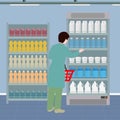 Person with a shopping basket near the supermarket shelves with drinks and dairy products