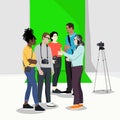Photographer team briefing inside a studio with green screen behind.