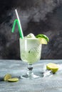 Basil gin alcoholic cocktail. Long alcohol drink with fresh basil leaves and limes, in highball glasses on concrete Royalty Free Stock Photo