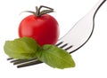 Basil leaf and cherry tomato on fork isolated on white backgrou