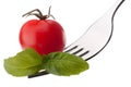 Basil leaf and cherry tomato on fork isolated on white backgrou Royalty Free Stock Photo