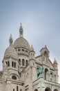 The basilicas of Sacre Coeur cathedral in Monmartre, with a sculpture of King Louis IX in the foreground.