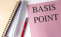 BASIS POINT text on pink paper with notebooks