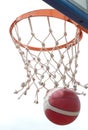 Baskeball going through basket ring ant net. a successful clear point in low angle view Royalty Free Stock Photo