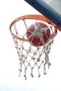 Basketball going through basket ring ant net. a successful clear point in low angle view Royalty Free Stock Photo