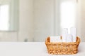 Basket with bath accessories such as soap bars, Cream and cosmetic tissues for body care on a white table over blurred bath Royalty Free Stock Photo