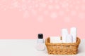 Basket with bath accessories such as soap bars, Cream and cosmetic tissues for body care on a white table over pink background Royalty Free Stock Photo