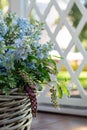 A basket with a bouquet of pale blue flowers.