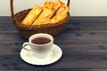 Basket with bread sticks, white porcelain cup and saucer