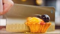 Basket cake with tangerine, kiwi and plum. Macro filming on a cooking tray. Cut the cake in half with a professional Royalty Free Stock Photo