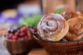 Basket with cinnamon rolls buns and berries on background selective focus