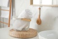 Basket with clean towel in bathroom interior