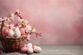 Basket with colorful Easter eggs and blooming flowers on the table on pink background, copy space. AI generated Royalty Free Stock Photo