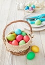 Basket of colorful easter eggs on wooden table Royalty Free Stock Photo