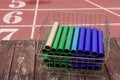 Relay batons in a medal basket on a deck looking over the track