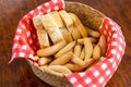 Basket containing freshly-cooked, crunchy golden-brown breadsticks, and a fluffy white loaf of bread
